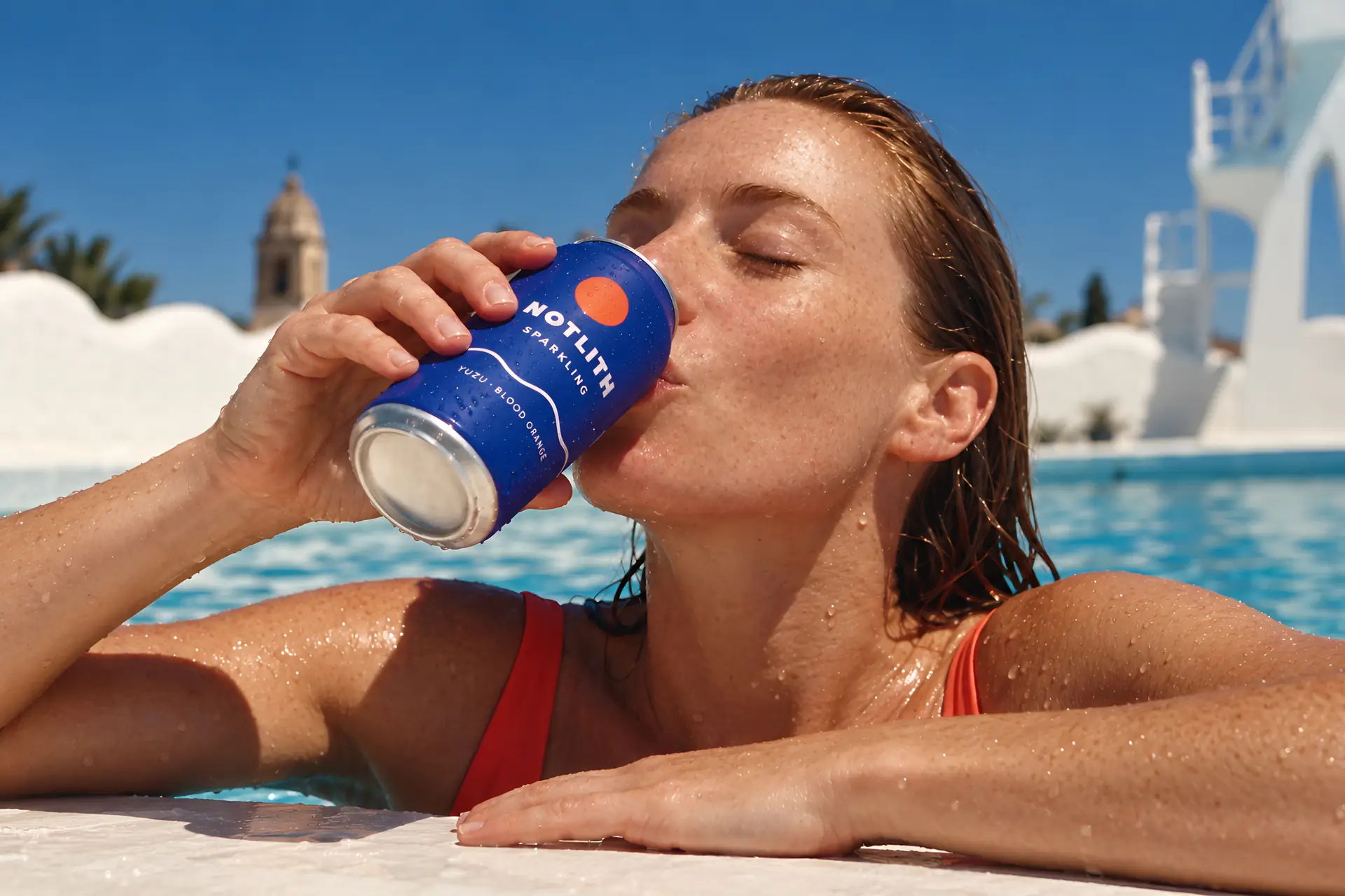 femme buvant dans une canette bleue dans une piscine