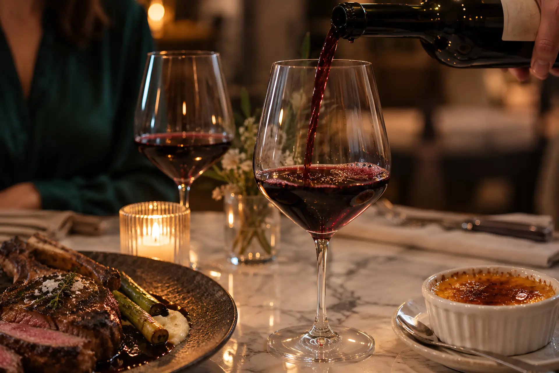table dressée avec steak et verres de vin