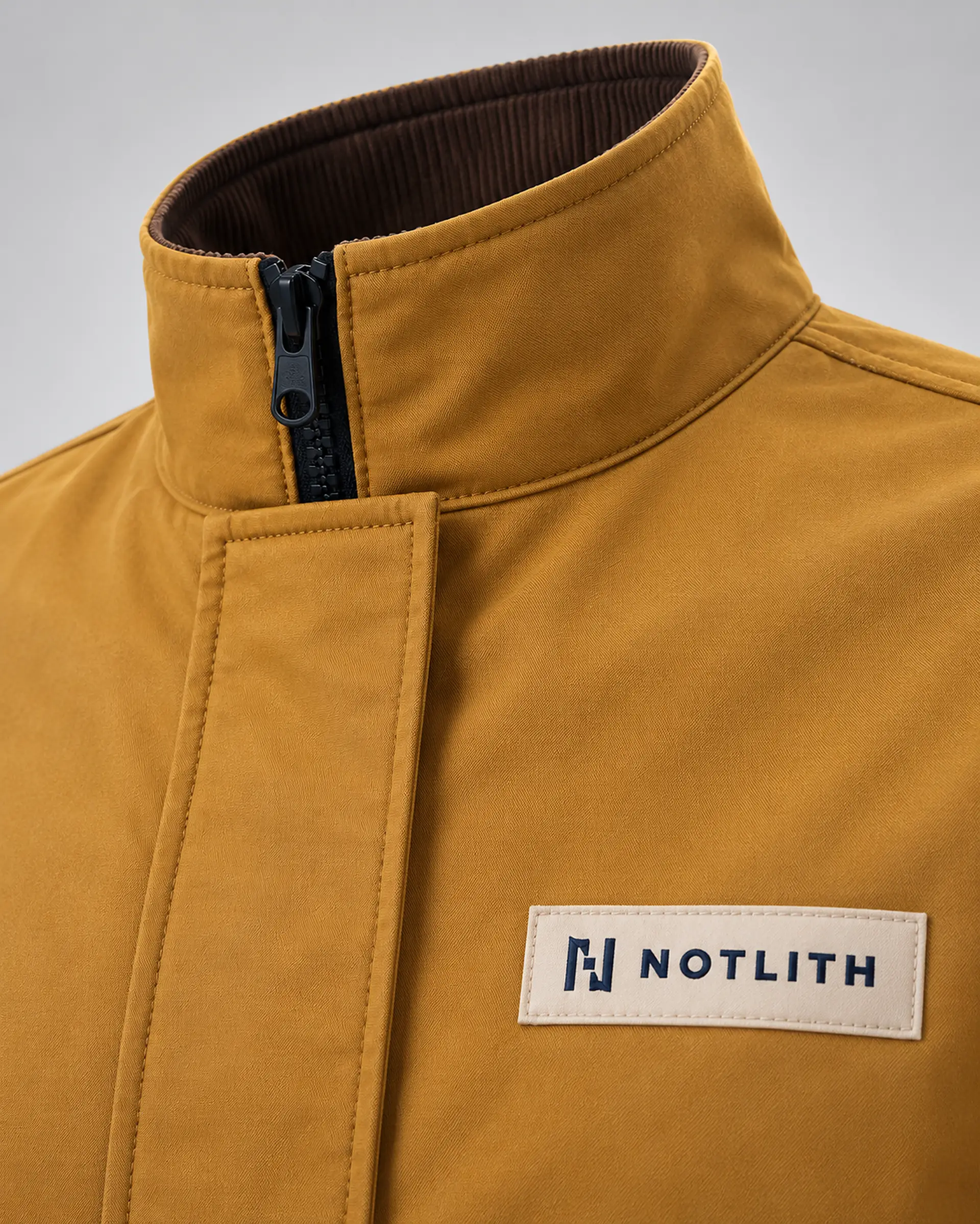 gros plan sur le col et l’étiquette d’une veste ocre